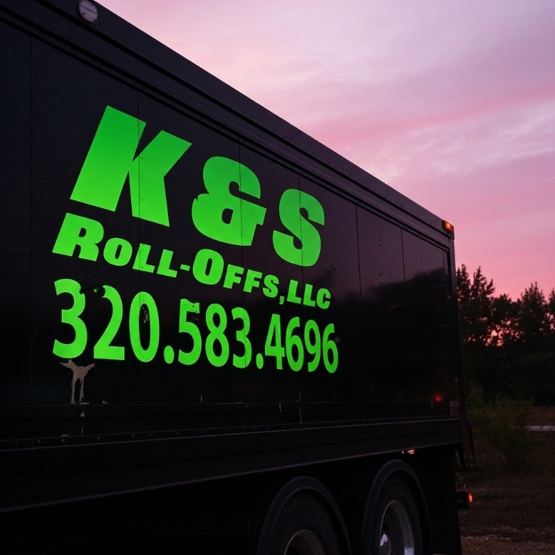 k&s roll-off dumpster with logo at sunset