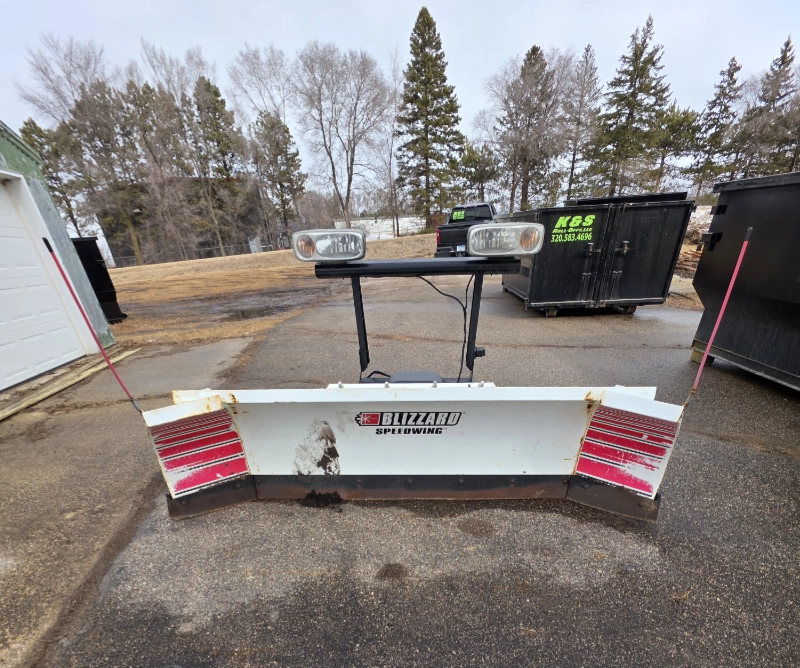 snow plow attachment on a driveway with mounted lights