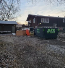 k&s roll-off dumpster outside a home with clutter ready for removal